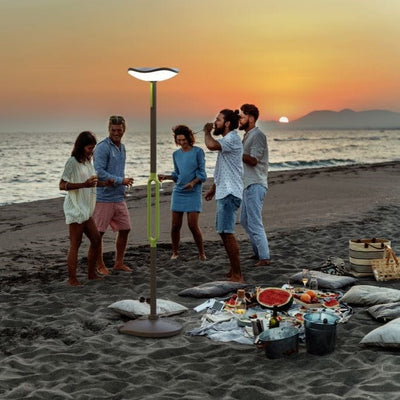 Beach gathering in the evening with the Lutec Poppy solar portable lamp post