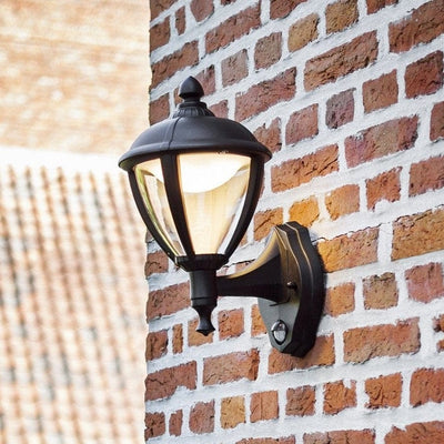 Outdoor wall lantern with PIR Motion Sensor fixed to a brick wall.